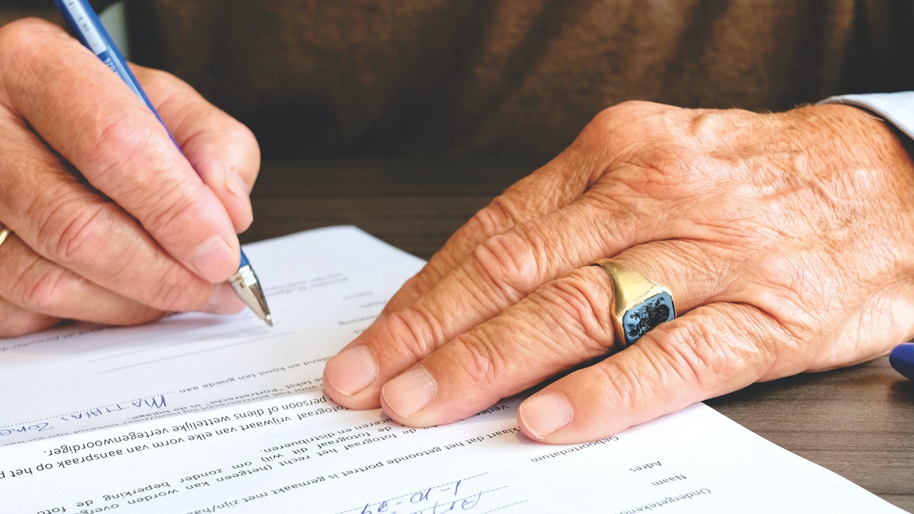 old man completing document