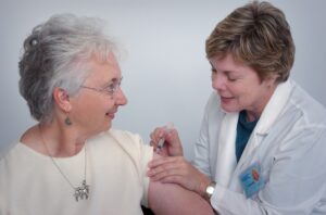 female doctor giving senior woman an immunization